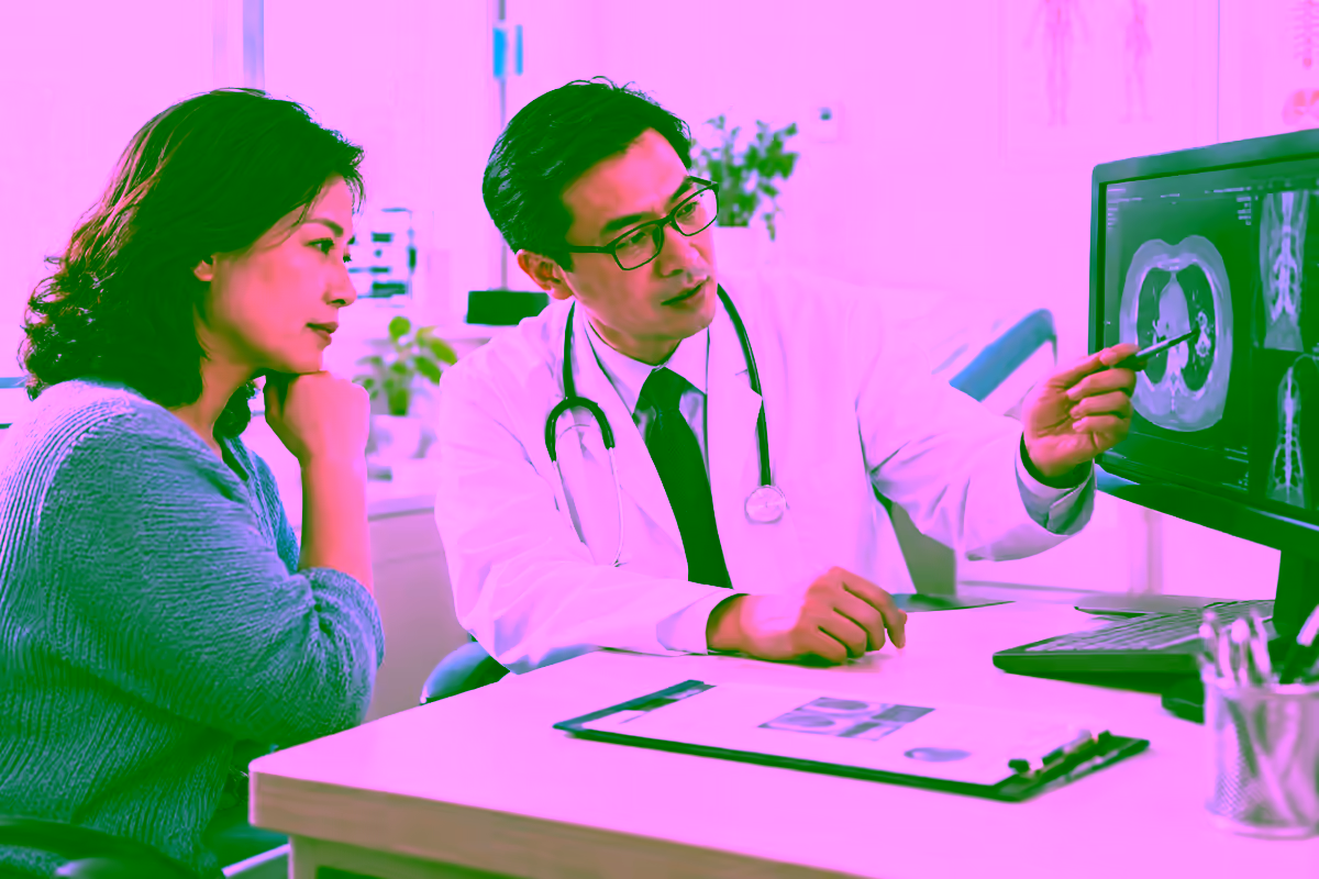 Bệnh nhân trao đổi với bác sĩ ung bướu bên cạnh phim chụp y khoa