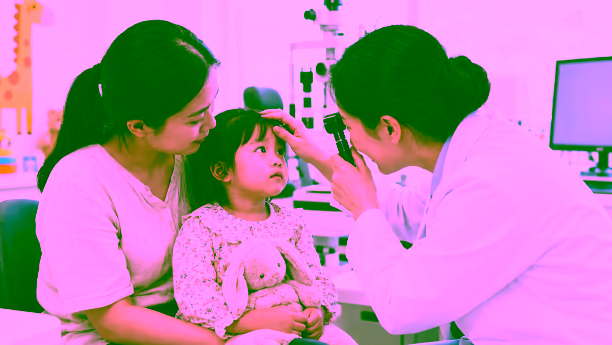 Bác sĩ khám mắt cho trẻ nhỏ cùng cha mẹ tại phòng khám chuyên khoa