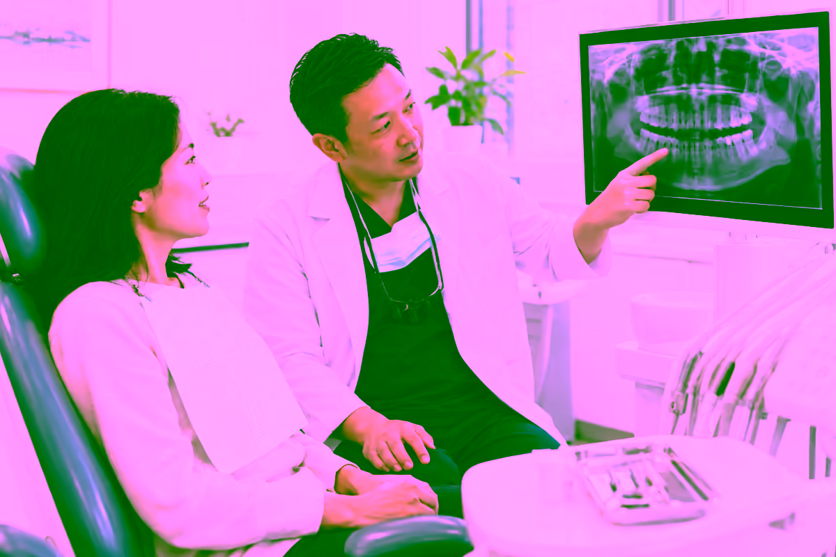 Bác sĩ nha khoa giải thích phim X-quang xương hàm cho người bệnh