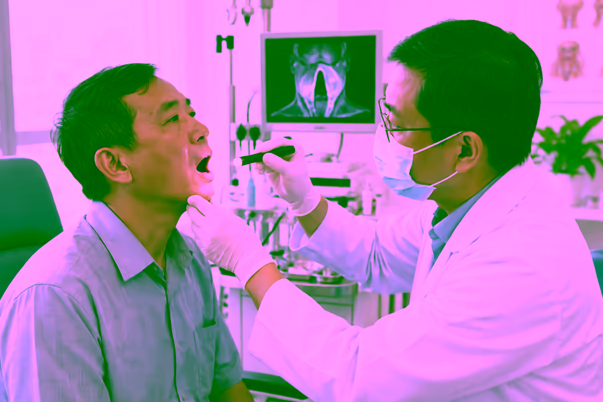 Bác sĩ tai mũi họng khám họng cho người bệnh khàn tiếng