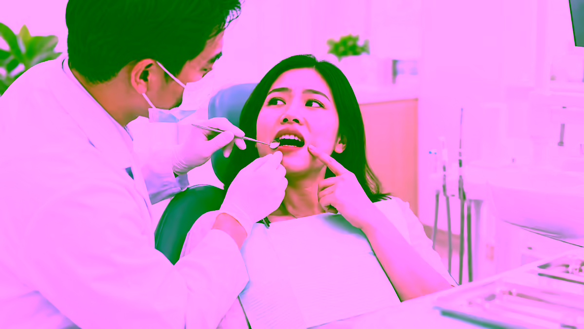 Bác sĩ nha khoa kiểm tra đường viền lợi cho người bệnh