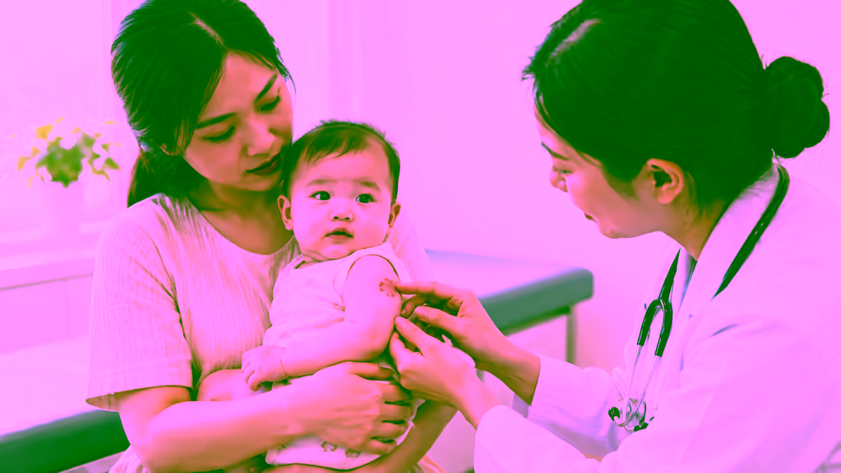 Bác sĩ da liễu kiểm tra vết bớt đỏ nhỏ trên cánh tay em bé cùng mẹ