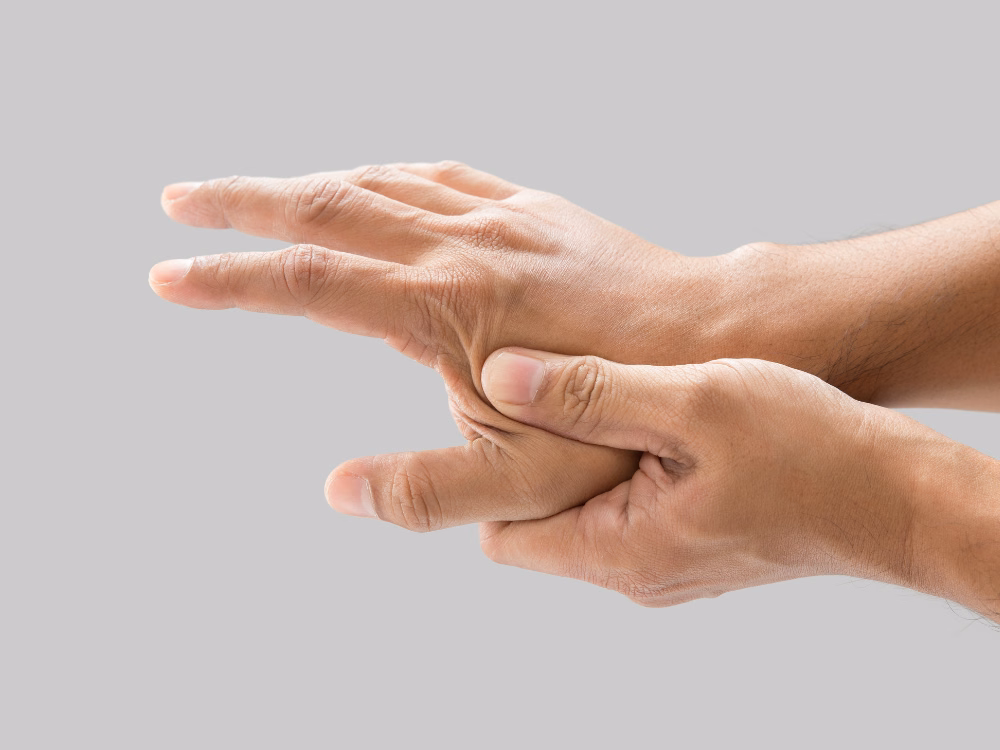 Người bệnh dùng tay xoa bóp bàn tay bị đau mỏi tê bì do suy giảm tuần hoàn ngoại biên