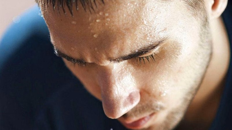 Người đàn ông bị toát mồ hôi đầm đìa vùng trán và mặt trong lúc ngủ