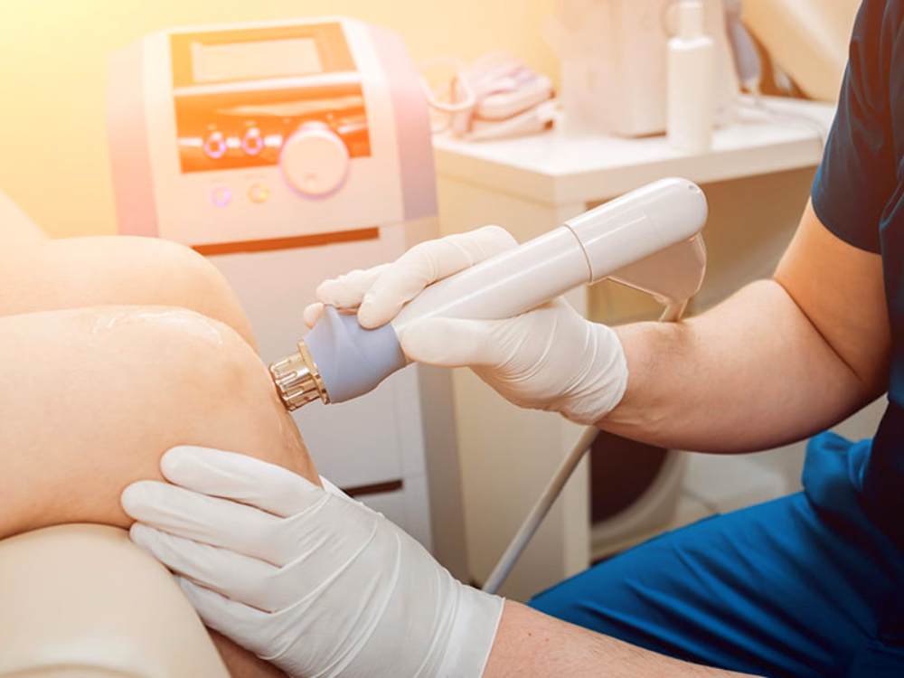 Bác sĩ sử dụng thiết bị sóng xung kích điều trị tổn thương cơ xương khớp tại vùng khớp gối cho bệnh nhân