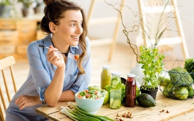 Người phụ nữ duy trì chế độ ăn uống lành mạnh nhiều rau củ quả tươi giúp phòng ngừa đau bụng trên