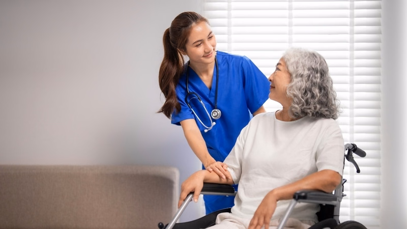 Chuyên viên y tế hỗ trợ người bệnh liệt nửa người tập đi lại an toàn sau đột quỵ