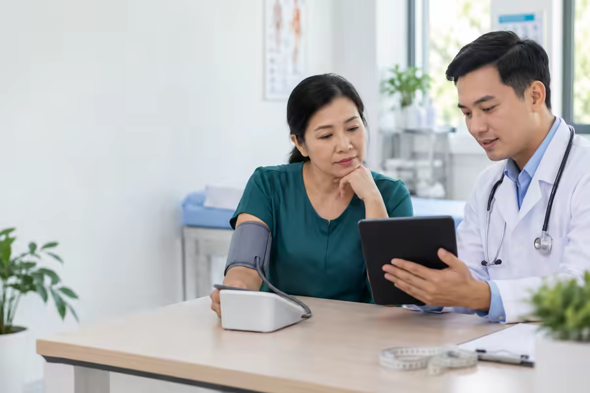 Người trưởng thành kiểm tra sức khỏe và huyết áp cùng bác sĩ để phát hiện nguy cơ đột quỵ