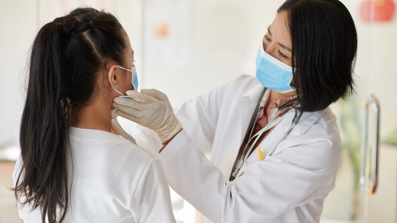 Hình ảnh bác sĩ chuyên khoa thăm khám vùng cổ và hàm khi có hạch sưng đau bất thường