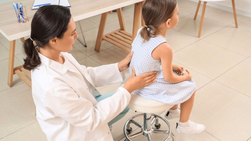 Chuyên viên vật lý trị liệu hướng dẫn điều chỉnh tư thế cho người bị vẹo cột sống