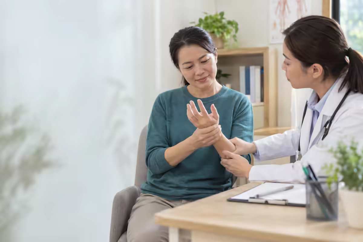 Người bệnh xoa bàn tay tê và được bác sĩ kiểm tra cảm giác nhẹ nhàng