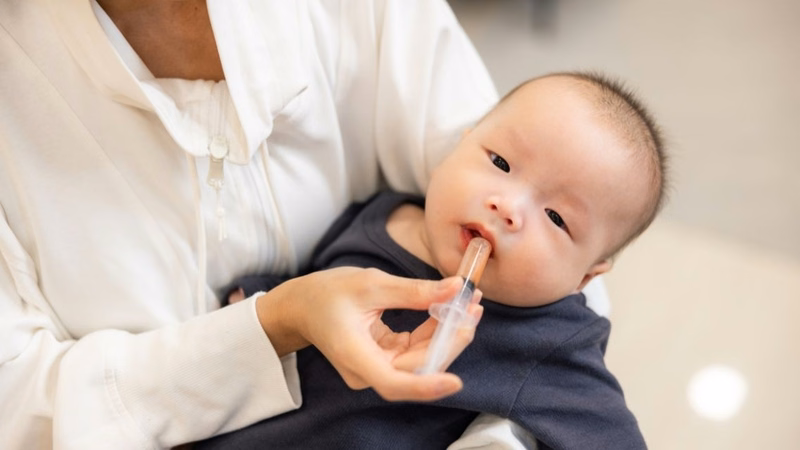 Hình ảnh minh họa việc cho trẻ uống thuốc kháng sinh cần tuân thủ theo chỉ định y khoa