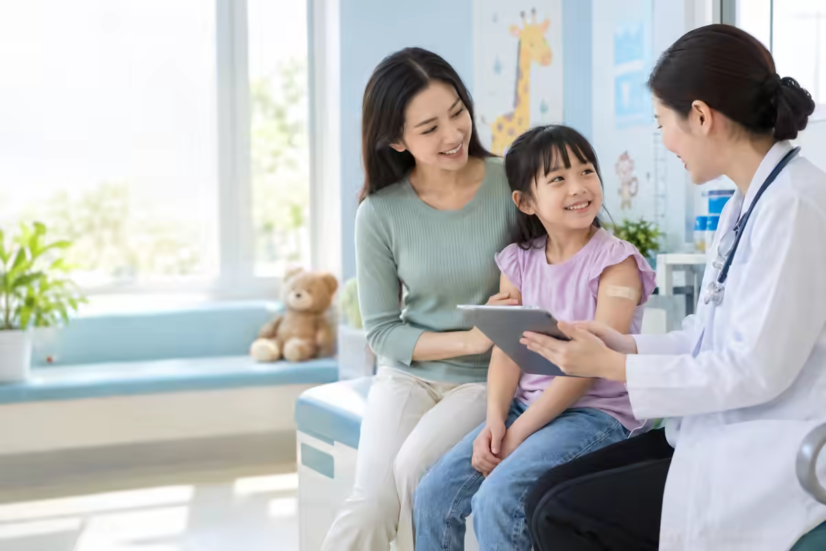 Trẻ em cùng cha mẹ được bác sĩ giải thích quy trình xét nghiệm máu